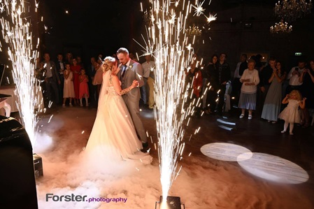 Ein Brautpaar tanzt auf der Hochzeit seinen Eröffnungstanz vor den Gästen mit Bodenfeuerwerk