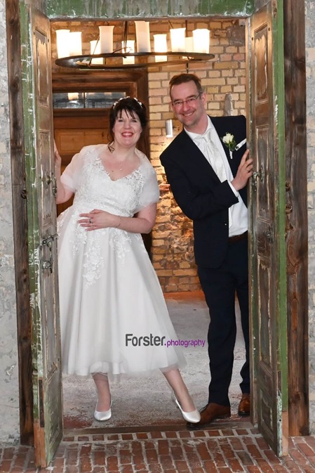Brautpaar schaut durch eine Tür beim Brautpaar-Fotoshooting